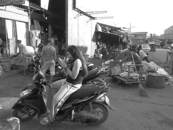 People on street in city against sky