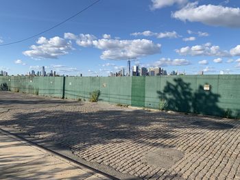 Panoramic view of street by buildings against sky