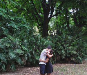 Couple embracing against plants at park