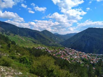 Scenic view of townscape and mountains against sky