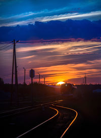 Silhouette road against sky during sunset