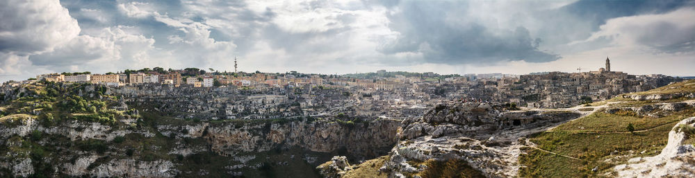 Panoramic view of buildings and rocks against sky