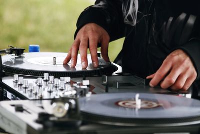 Midsection of dj playing music on turntable