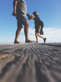 Low section of people standing on beach against clear sky