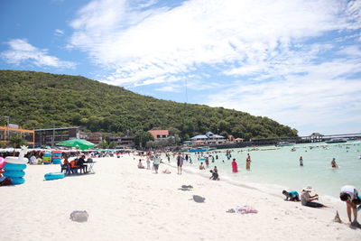 Group of people on beach against sky