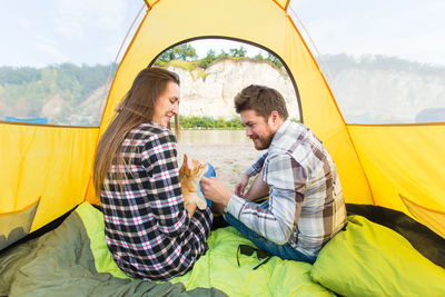 Young couple sitting on tent