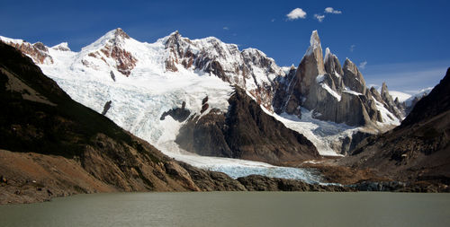 Scenic view of lake by snowcapped mountain against sky