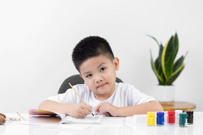 Portrait of cute boy holding table