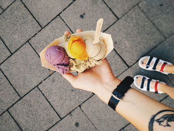 High angle view of person holding ice cream on footpath