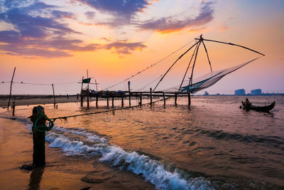 Pier over sea against sky during sunset