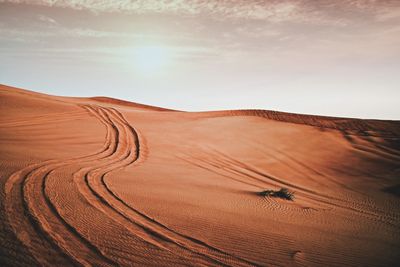 Scenic view of sand dune against sky