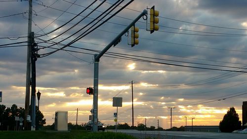 Electricity pylon against cloudy sky