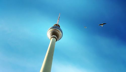 Low angle view of communications tower against blue sky