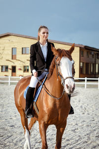 Portrait of woman riding horse on snow