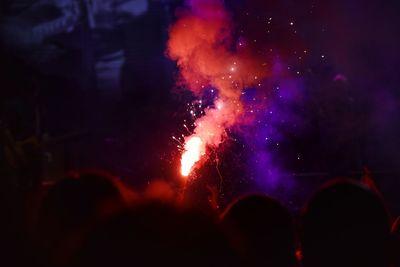 People watching firework display at night