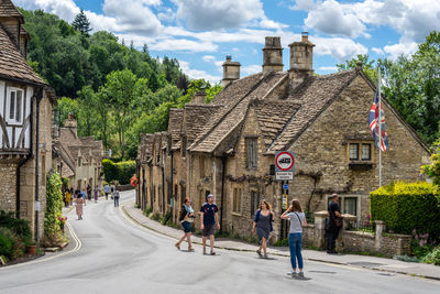 People walking on street amidst buildings in city