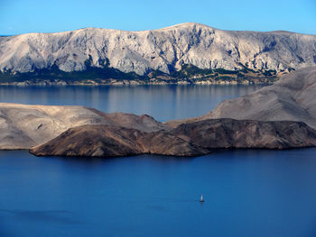 Scenic view of lake and mountains against blue sky