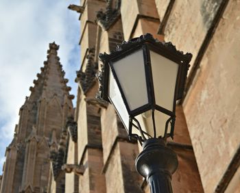 Low angle view of street light by building