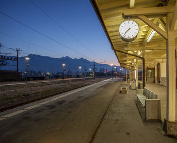 Railroad station platform against mountains and sky