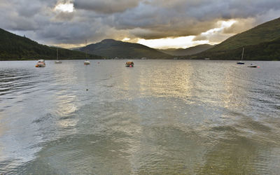 Scenic view of sea and mountains against sky