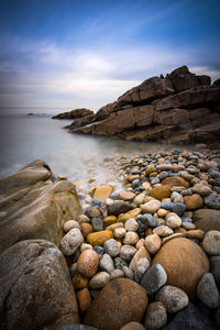 Rocks in sea against sky