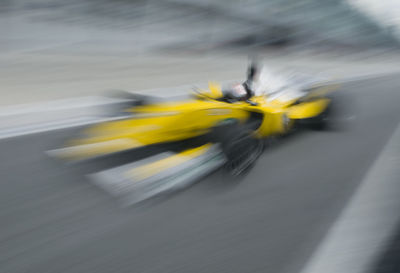 Blurred motion of yellow riding motorcycle on road