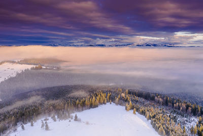 Scenic view of snow covered landscape against sky during sunset