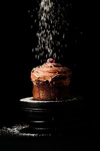 Close-up of cake on plate against black background