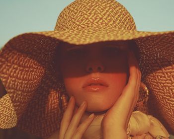 Close-up portrait of serious young woman wearing hat