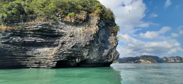 Rock formation in sea against sky