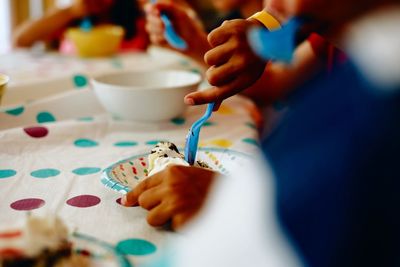 Cropped image of kids eating cake