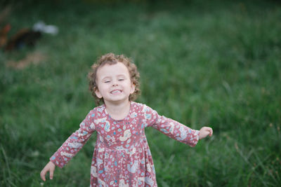 Portrait of cute girl standing on field