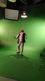 Man looking up while standing below light in studio