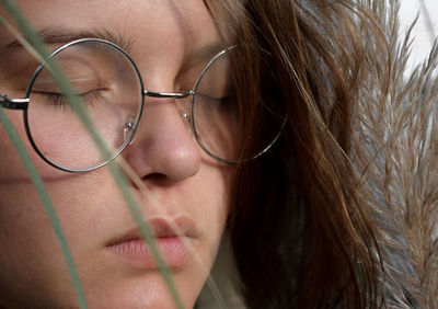 Close-up of young woman with eyes closed wearing eyeglasses