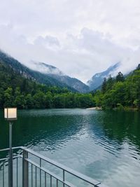 Scenic view of lake by mountains against sky
