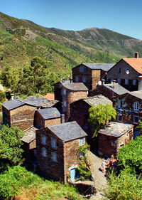 Buildings by mountain against clear sky