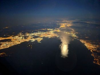 Aerial view of sea and cityscape at night