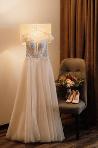 View of wedding dress hanging against wall at home