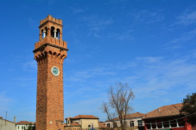 Low angle view of clock tower against blue sky