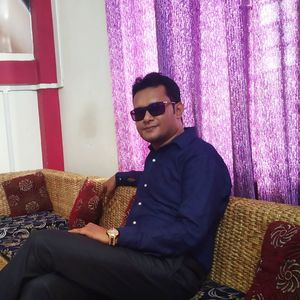 Young man wearing sunglasses sitting on sofa at home