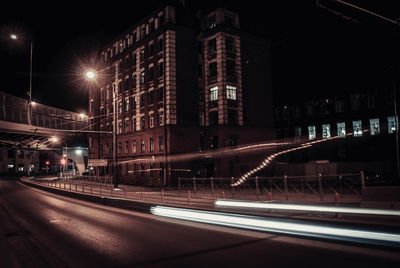 Light trails on street against buildings at night