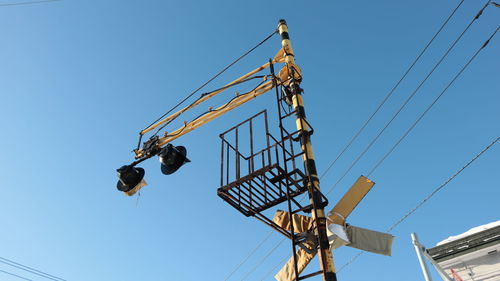 Low angle view of crane against clear blue sky