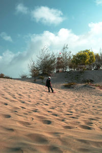 Full length of man climbing on land against sky