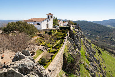 Marvao castle on the top of a mountain with beautiful green landscape behind on summer, in portugal