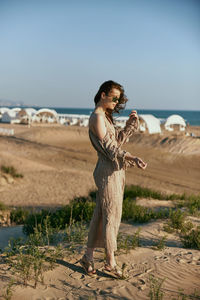 Rear view of woman standing at beach