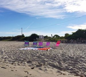 Multi colored umbrellas on beach against sky