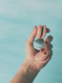 Close-up of hand holding blue against sky