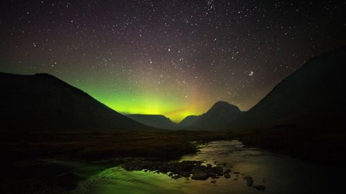 Scenic view of lake against sky at night