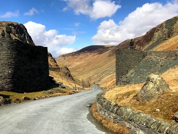 Road amidst mountains against sky