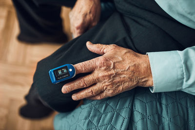 Senior man measuring the degree of oxygen saturation of the blood and heart rate at home